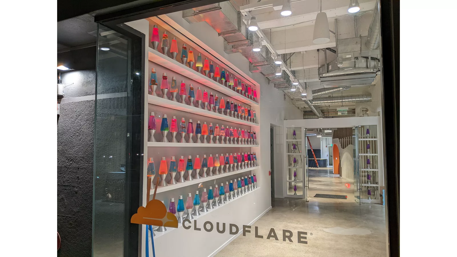 Lava lamp wall at Cloudflare office -1.jpg. A wall of lava lamps in the entrance area of the Cloudflare offices at 101 Townsend Street in San Francisco (seen from the street through the window, some window reflection visible). Ilustracija uz vest: Cloudflare: VoidZero ubrzava JavaScript alate, pojedini testovi pokazuju višestruka ubrzanja