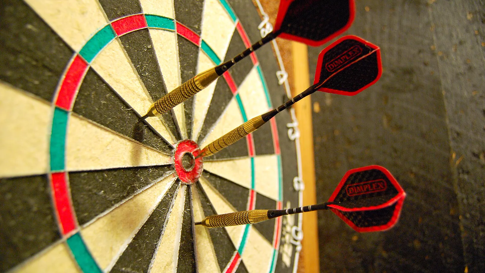 Darts in a dartboard.jpg. Original description was I took this shot while playing darts with friends at Desperate Annie's in Saratoga Springs, NY.. Ilustracija uz vest: Pikado: Cameron Menzies pobedio Van Veena i osvojio drugu titulu u 2026.